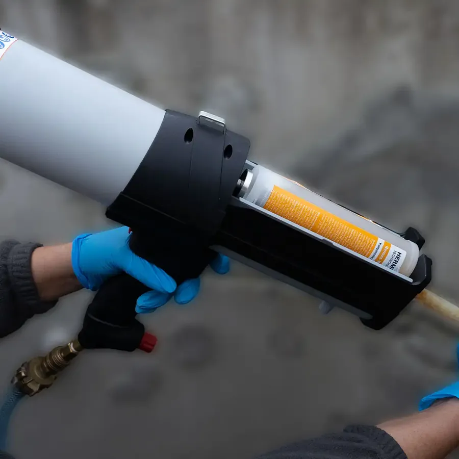 Pneumatische Kartuschenpresse HermesGun400 Version B mit eingesetzter Doppelkammerkartusche in der Hand